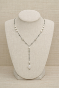 Necklace with pearls and stones on a mannequin bust against a beige background