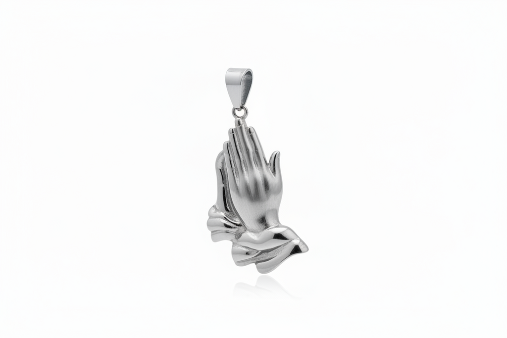 A polished silver pendant shaped like praying hands, shown against a clean white background with a subtle reflection below.