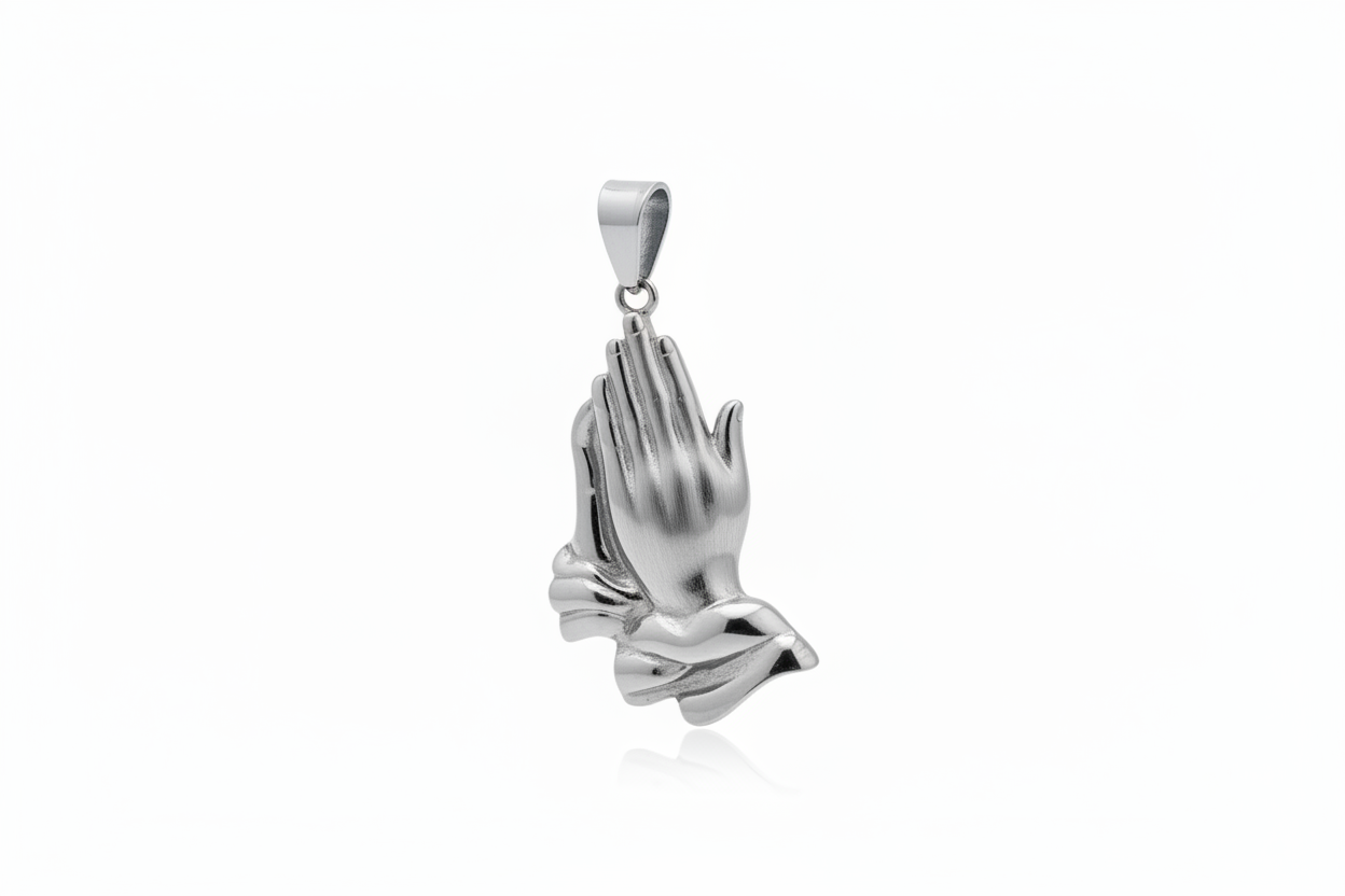 A polished silver pendant shaped like praying hands, shown against a clean white background with a subtle reflection below.